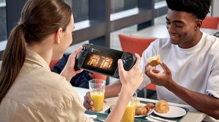 A young man and woman game together over breakfast.