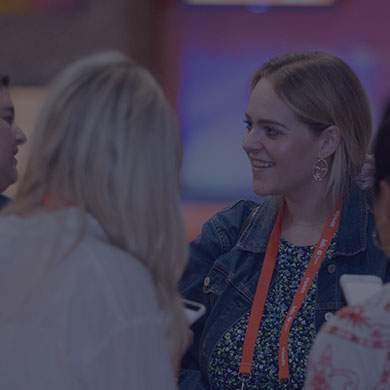 a blonde woman wearing denim talking to another human