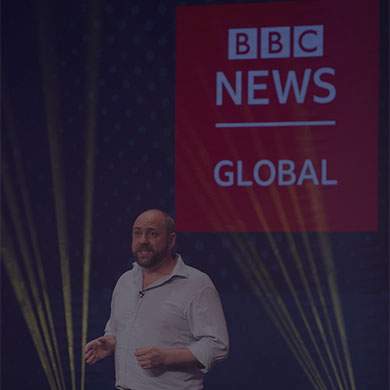 Man in white shirt talking in front of BBC Global logo
